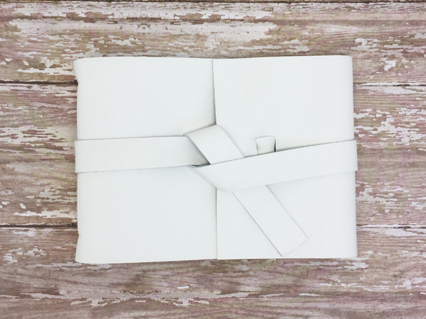 White leather guestbook on wood background