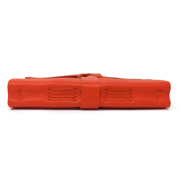 Spine view with stitching detail of orange leather notebook