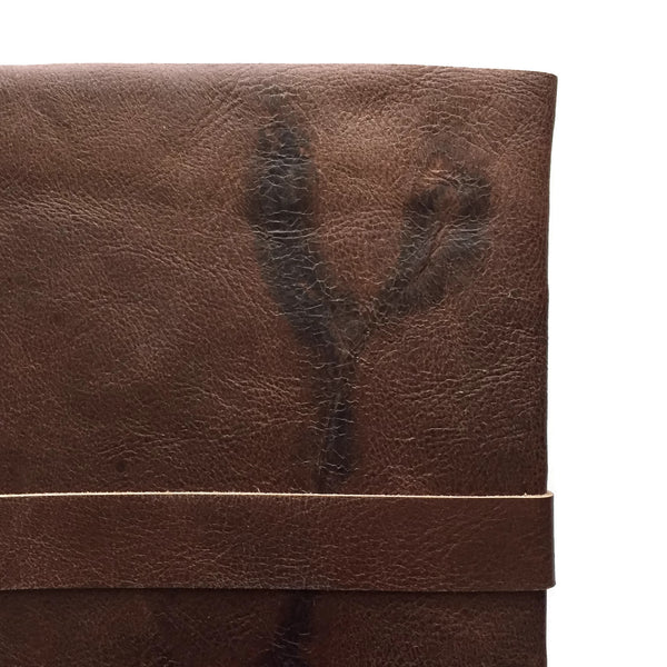 Back view detail of chocolate brown leather journal with cattle brand scar